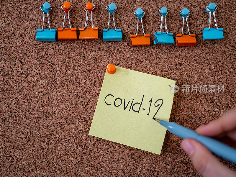 贴在公告板上的带有covid - 19文字的便条